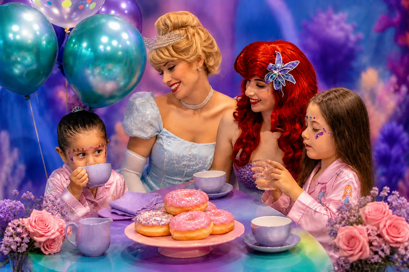 Cinderella and Ariel sharing morning tea and pink donuts with two little guests in princess pajamas