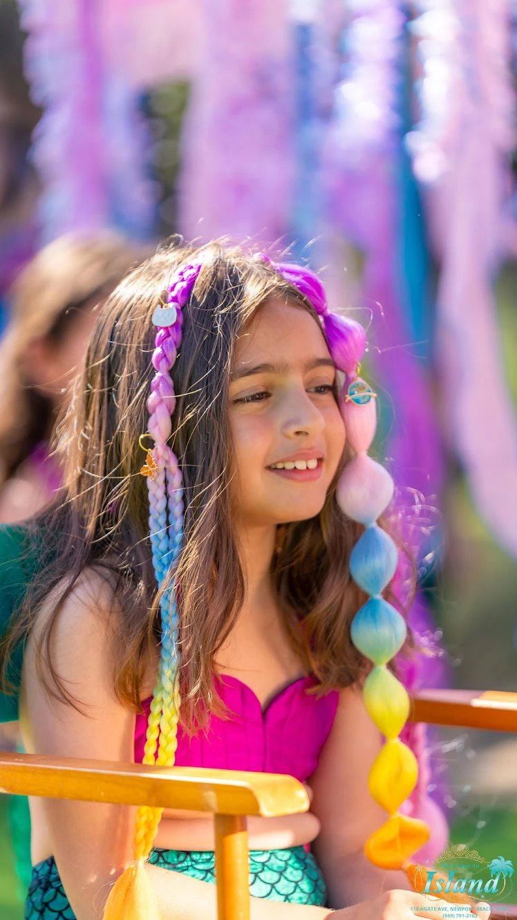 A mermaid makeover with colorful braids and face gems at Mermaid Cove