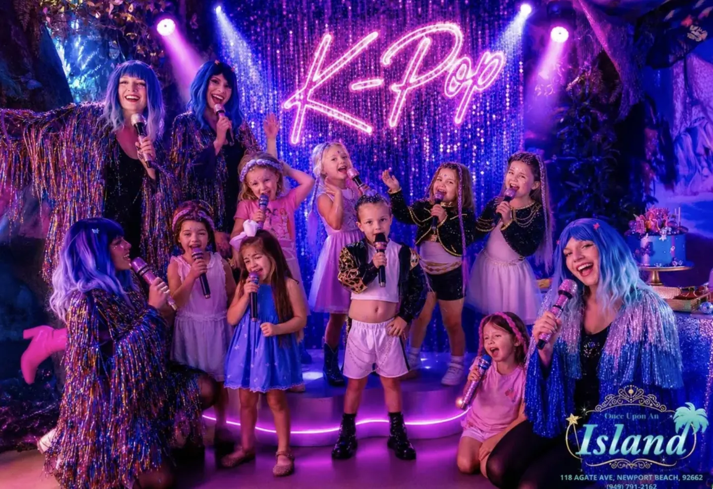 The whole K-Pop party crew singing under the neon sign with their idol hosts