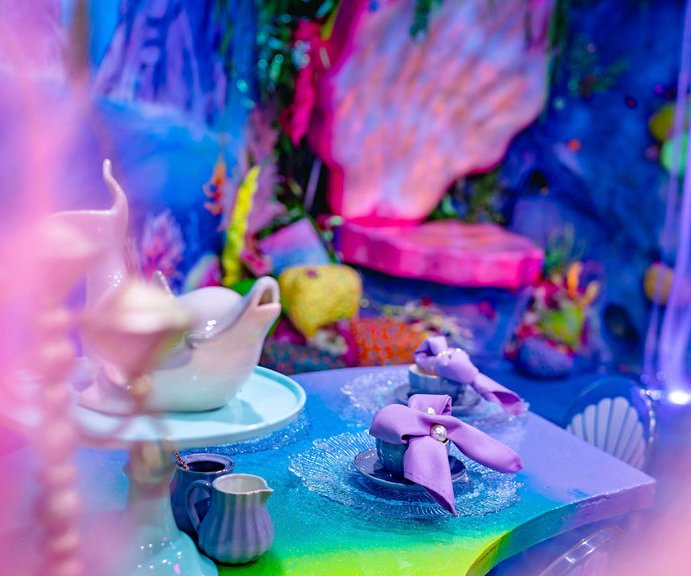 A lagoon tea table set with shell teacups and a ribboned napkin at a Signature Mermaid Party
