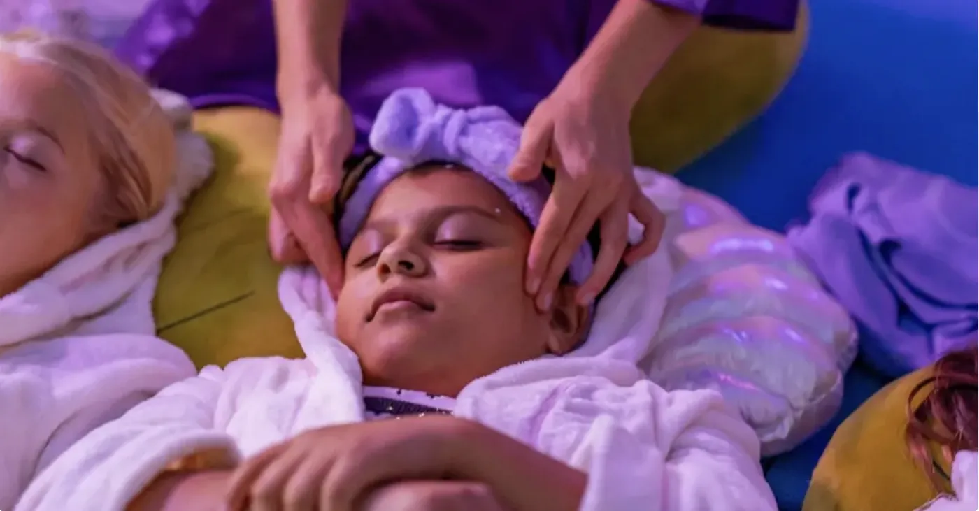 A mermaid host giving a gentle head massage during the Sea Spa Party