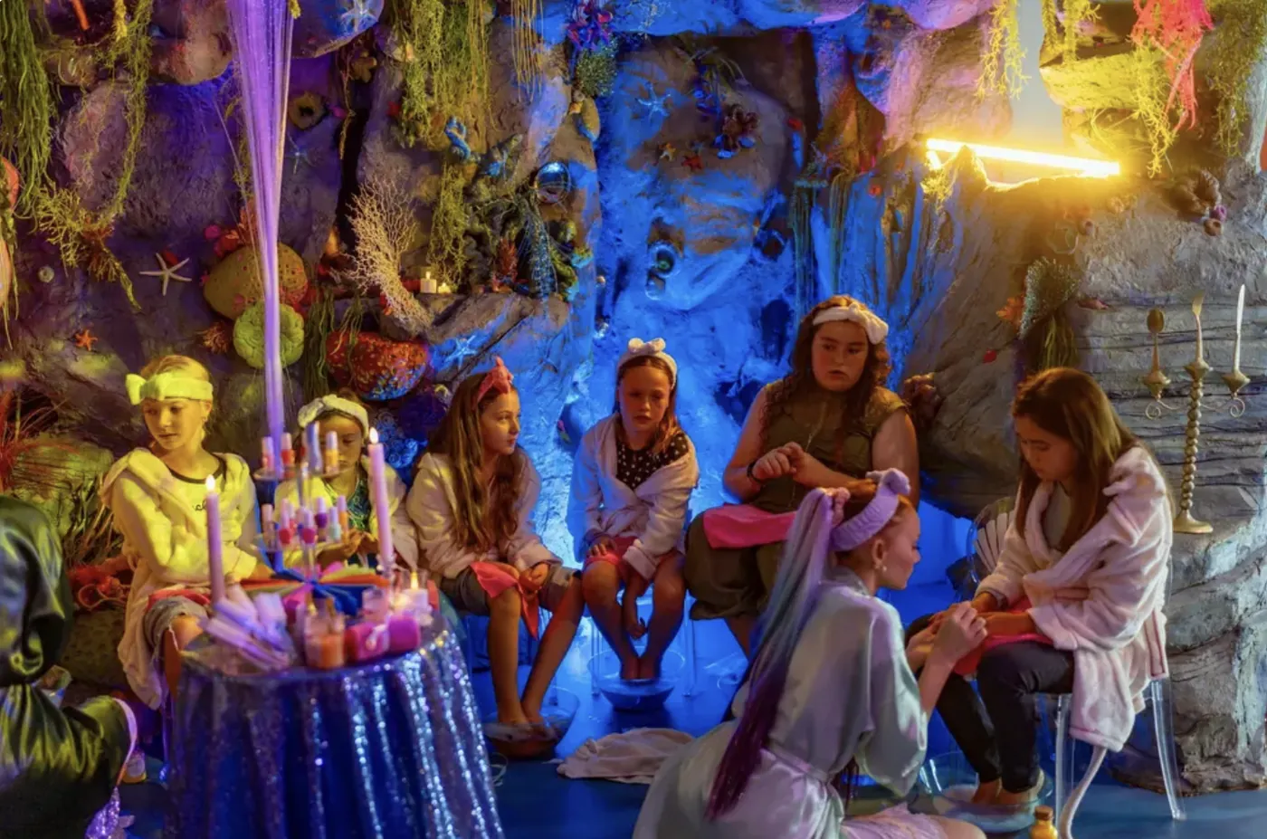 Girls in robes at pampering stations inside the mermaid grotto