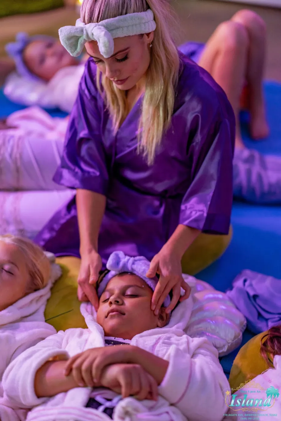 A spa host in robe giving gentle head massages during relaxation time