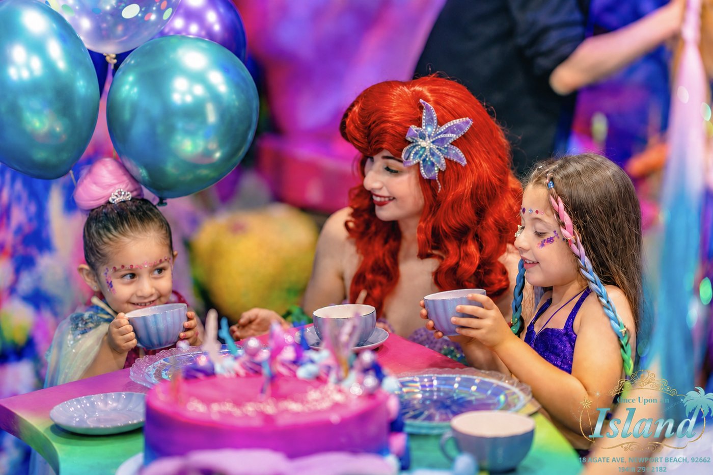 A princess host and a Neverland Mermaid sharing tea with two children at a Princess Tea Party in Newport Beach