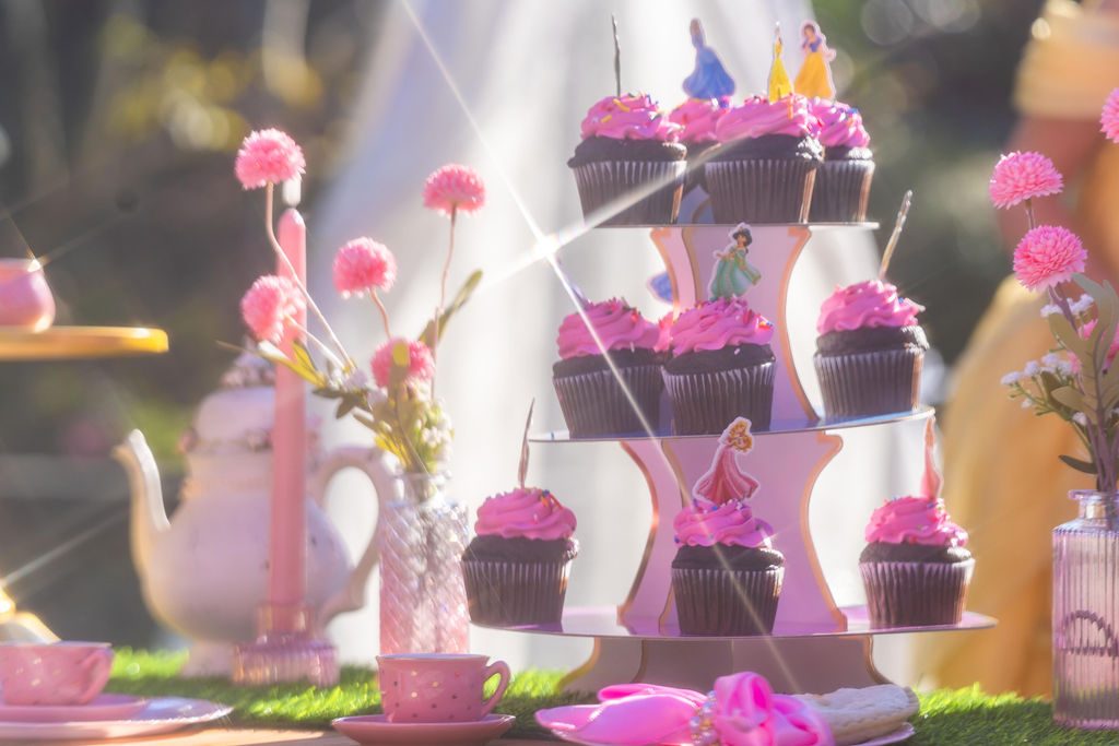 A tiered cupcake stand on the dessert table at a travel party