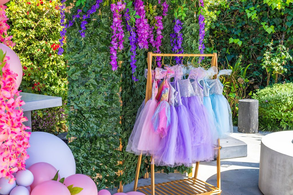The dress-up station at a travel party, with a costume on the rack for every child