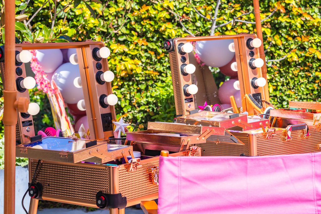 Two lighted salon mirrors set up outdoors as the makeover stations at a travel party