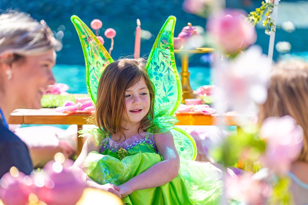 A child in fairy wings laughing at her travel party