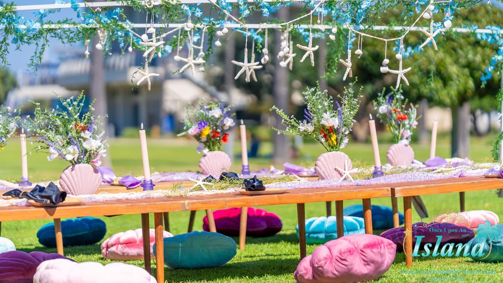 A starfish and floral canopy strung above the table at a mermaid travel party
