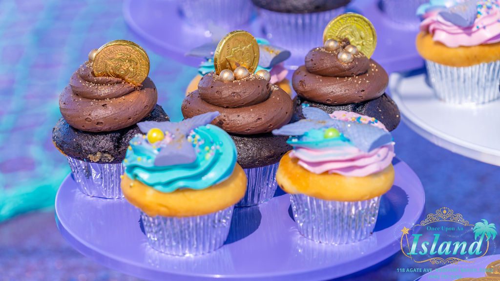 Mermaid themed cupcakes on the dessert stand at a travel party