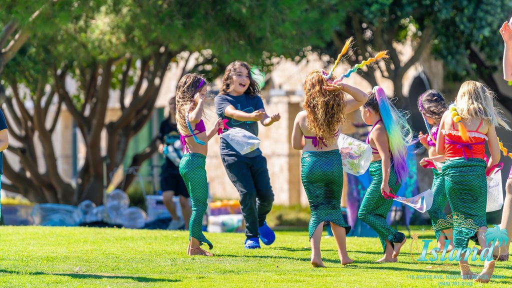 Children running across the grass during the treasure hunt at a travel party