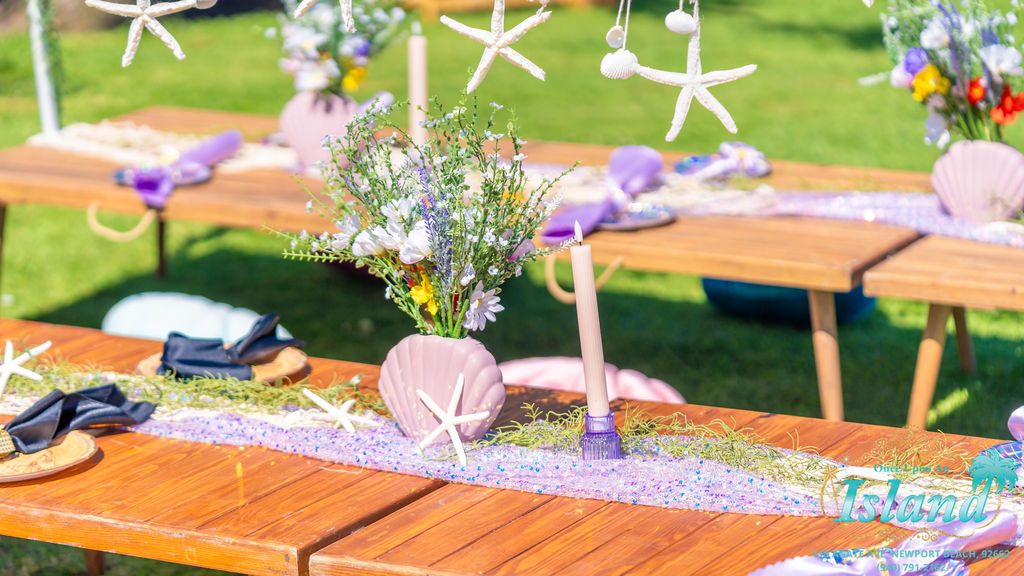 Shell plates, starfish and a wildflower table runner at a mermaid travel party