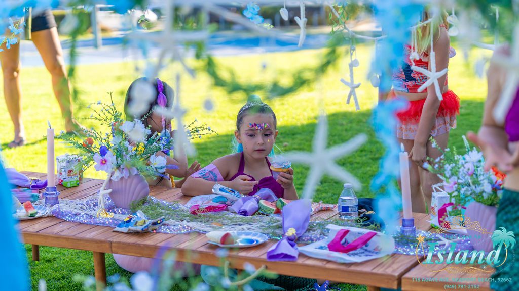 A child at the decorated table with the snack and drink our team brought and served