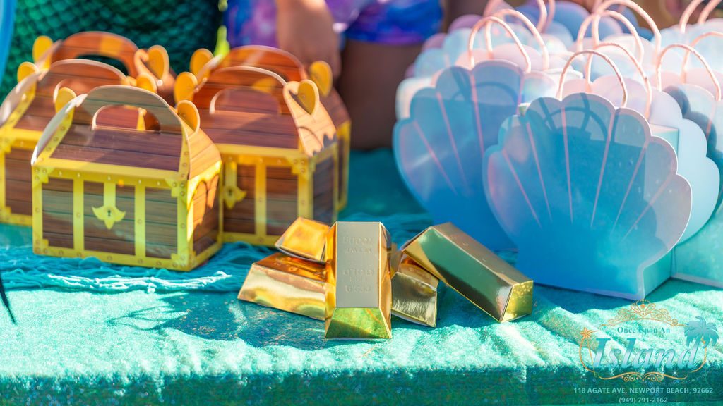 Treasure chests and shell favours laid out on the table at a mermaid party
