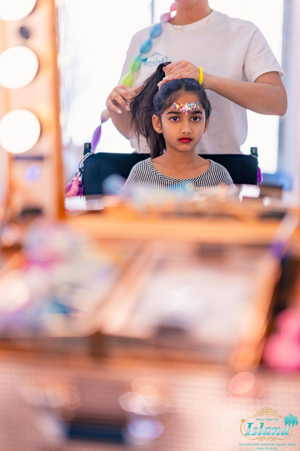 A guest having her hair styled at a Pop Star Party
