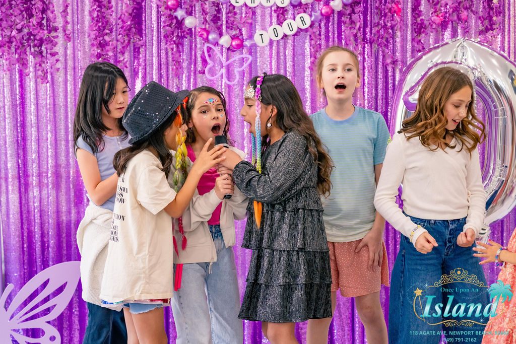 Girls singing into the microphone at a Pop Star Party at home