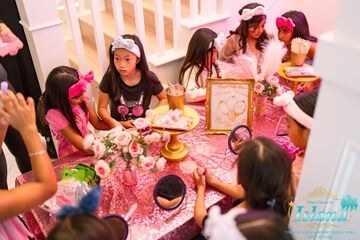 Girls gathered around a pink spa tea table at a Spa Tea Party brought to a home in Orange County