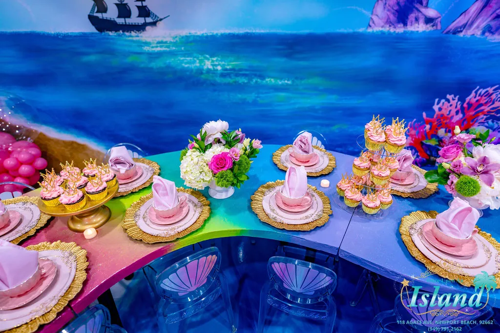 Crowned cupcakes and florals across the shell-chair tablescape
