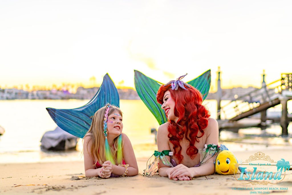 The Mermaid Princess with a birthday girl in her own tail on the sand at sunset
