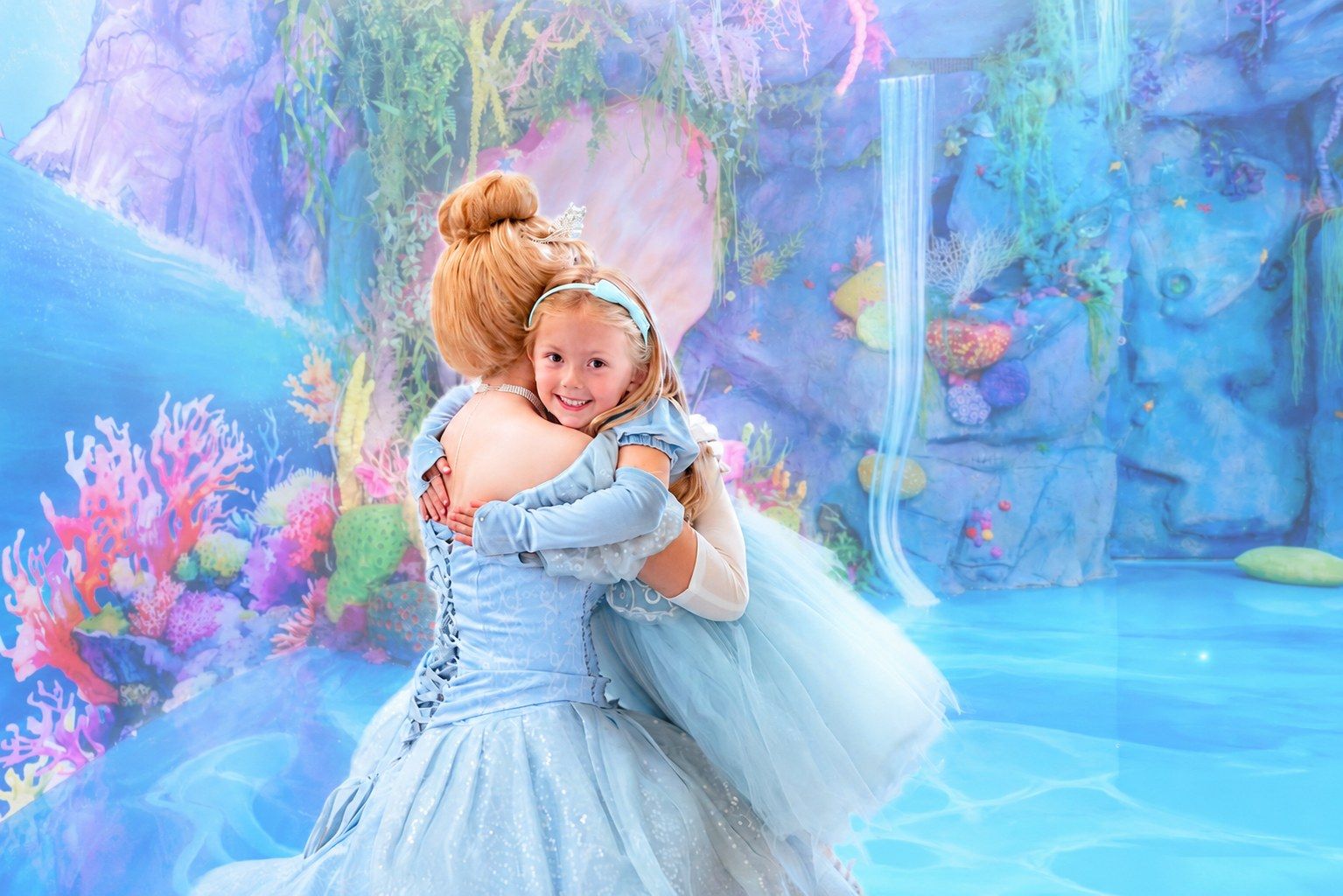 A child embracing her favorite princess in the mermaid lagoon at Once Upon an Island