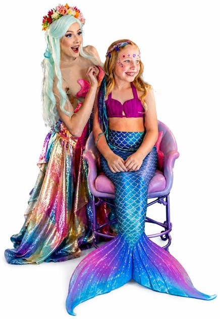 A professional mermaid styling a child&rsquo;s hair in our mermaid salon