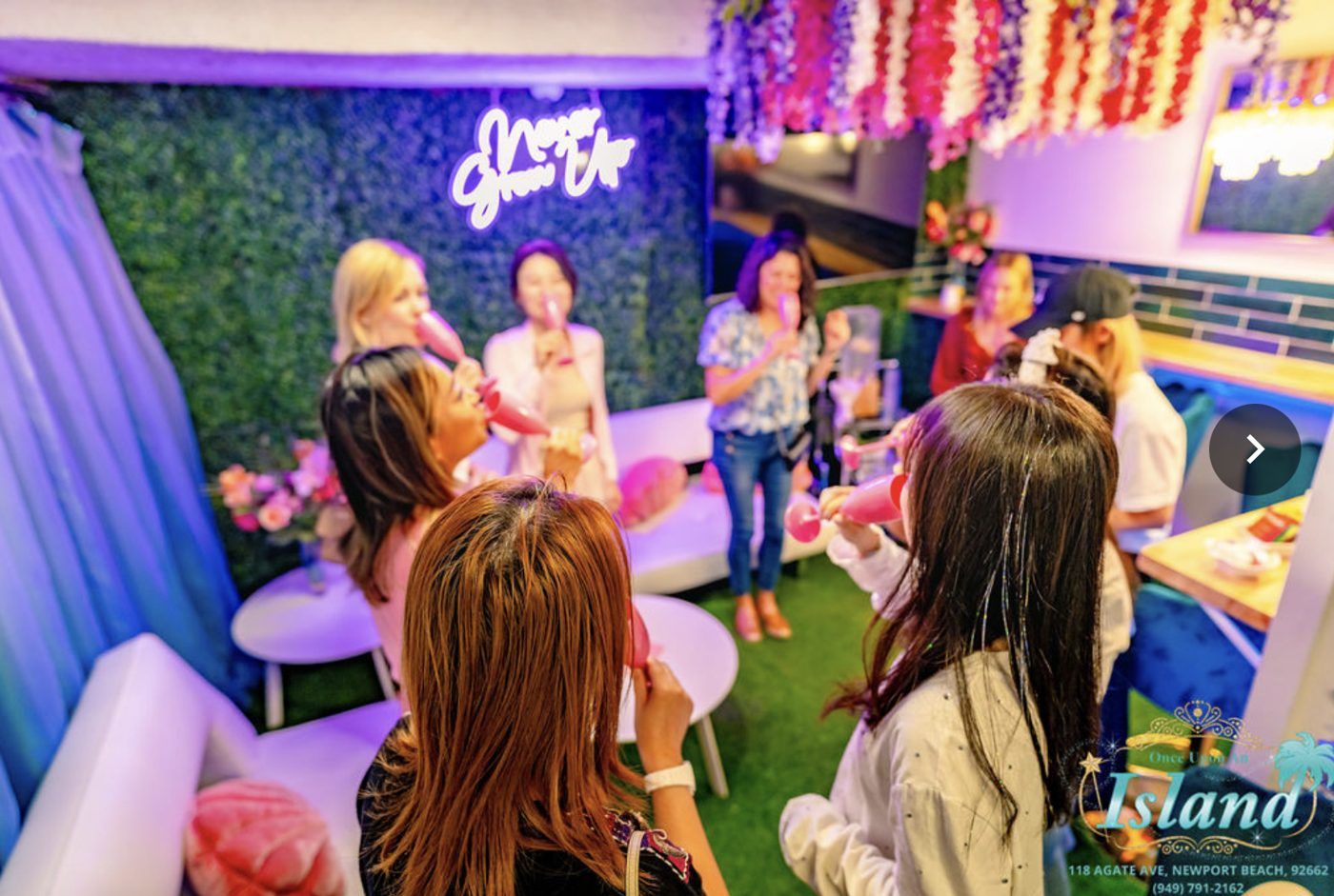 Moms toasting under the Never Grow Up neon in our parents lounge