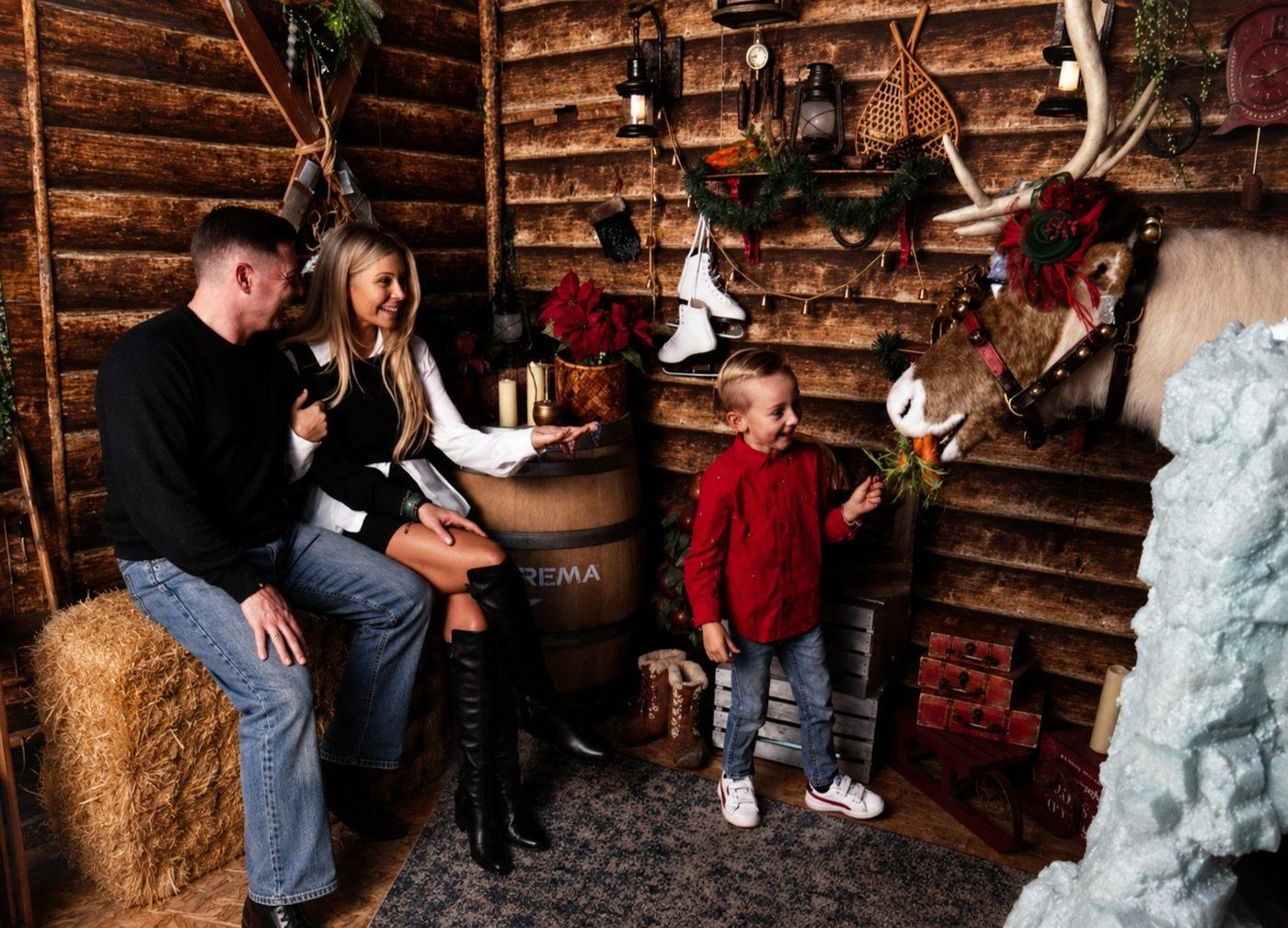 Cruise feeding a carrot to the reindeer while Heather and Brad watch, inside Once Upon a Christmas