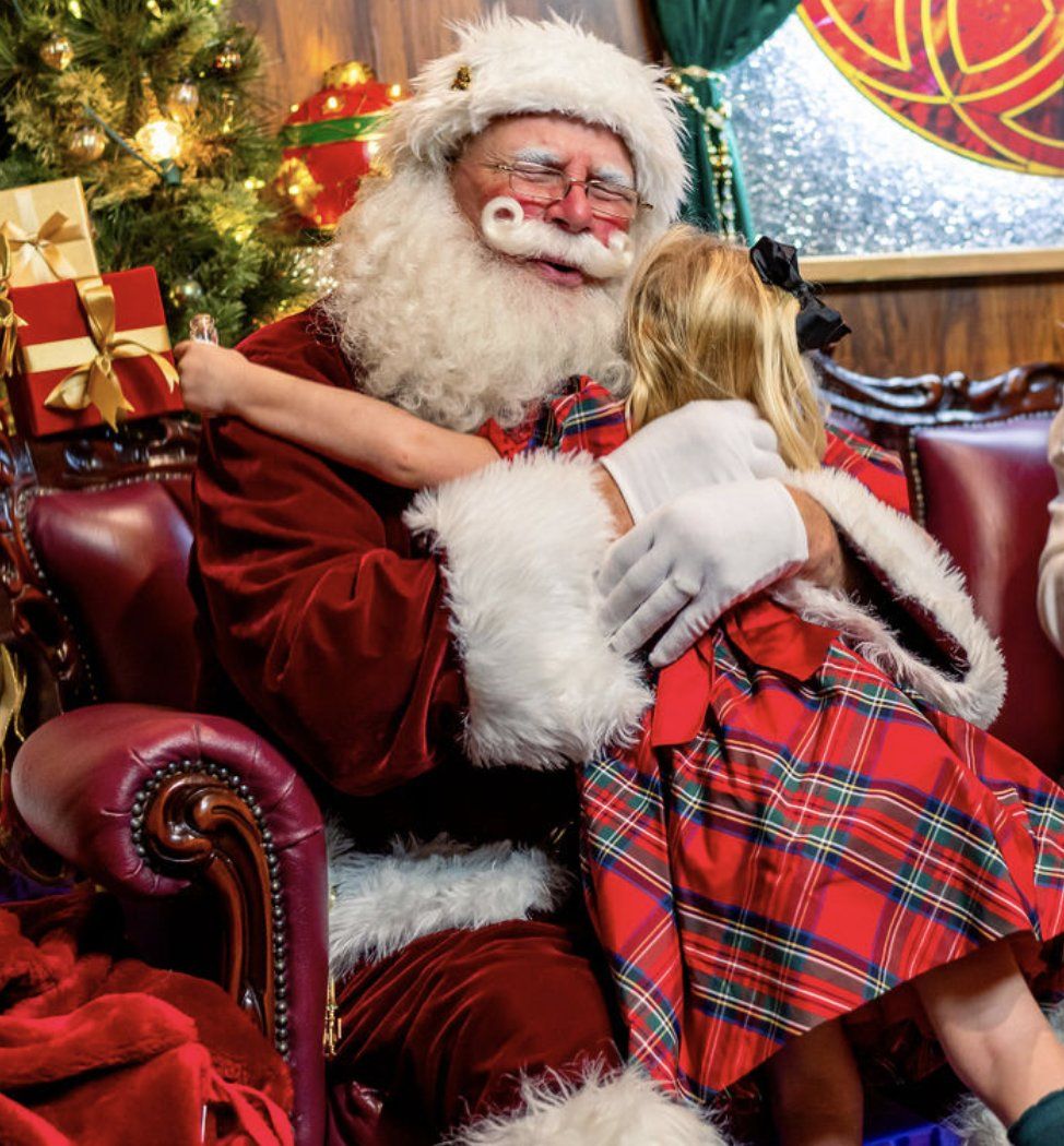 Santa hugging a child in his cottage at Once Upon a Christmas